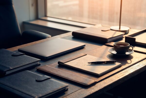 Healthcare executive desk with a laptop and proposal folders from a healthcare digital marketing company.