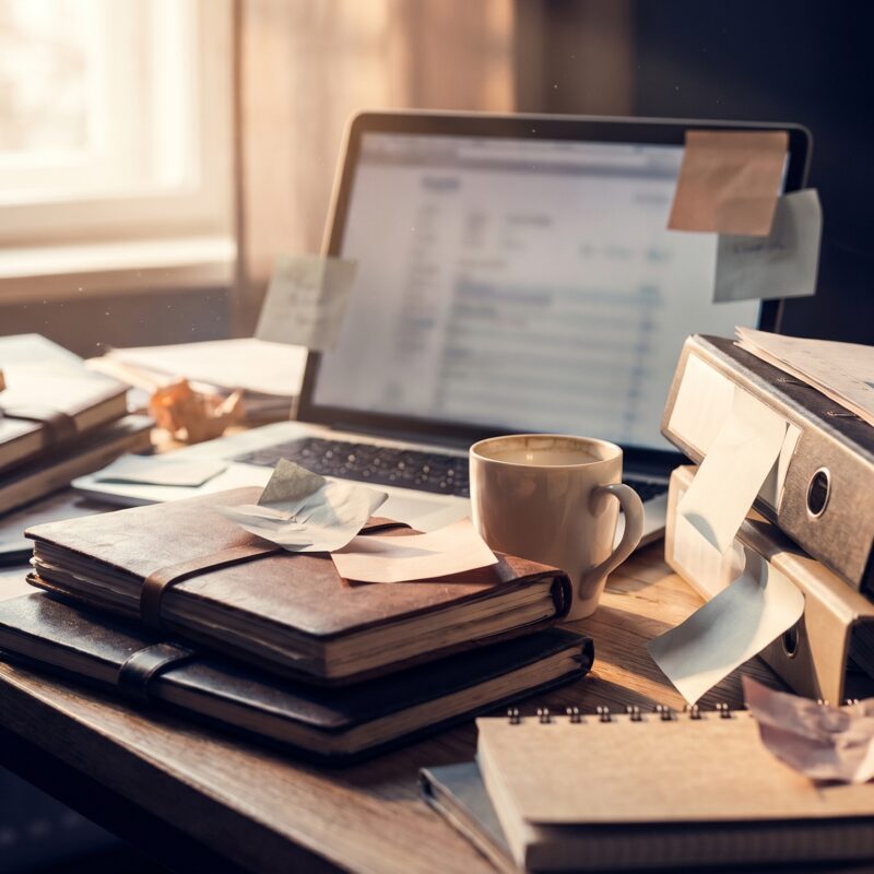 Layered strategy documents, analytics charts, and a laptop on the desk of a healthcare digital marketing expert.