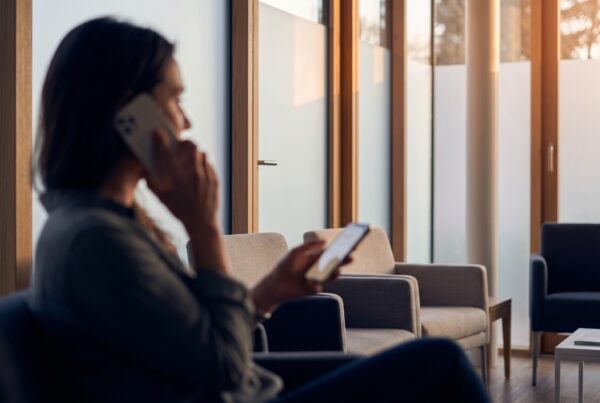 Patient in a modern clinic using a smartphone to experience the future of chatbots in healthcare.
