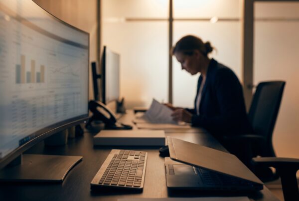 Clinician reviews data at a secure workstation using HIPAA-compliant AI in a clinic with warm lighting.