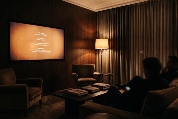 Large television glowing amber in a dimly lit living room, ready for a 210 Digital streaming channel movie.