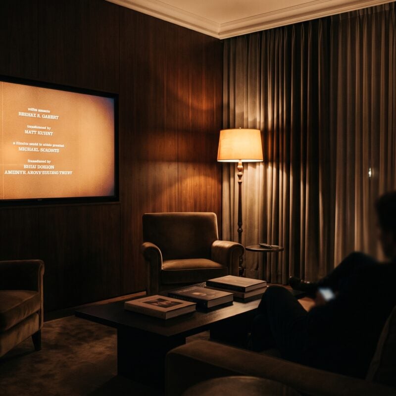Large television glowing amber in a dimly lit living room, ready for a 210 Digital streaming channel movie.