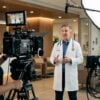 Physician recording a provider-led healthcare video on a cinematic production set